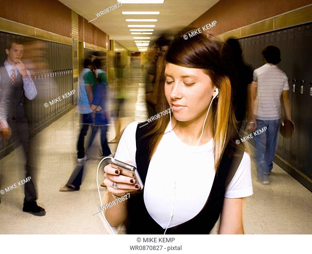 High School girl at school listening to MP3 player