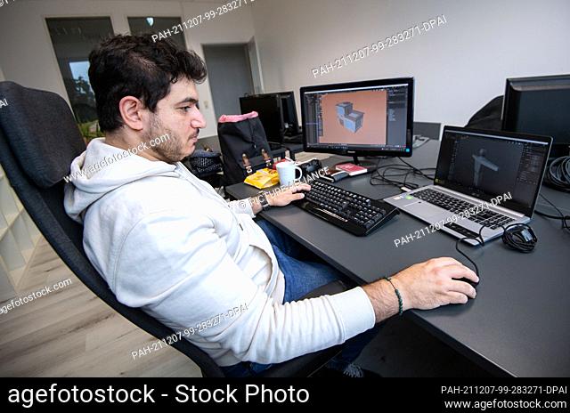 PRODUCTION - 19 November 2021, Baden-Wuerttemberg, Ludwigsburg: Rawand Ahmad, computer game developer, sits at his desk. For his concept for a computer game...