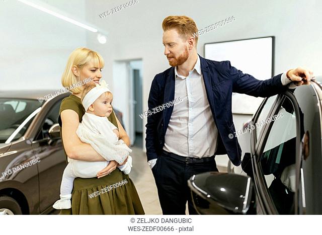 Family in car dealership choosing family vehicle