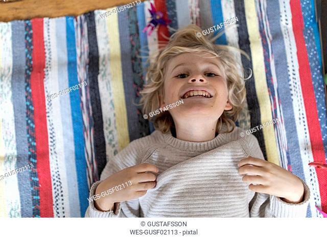 Top view of cheerful boy lying on the floor