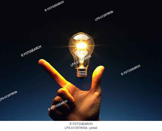 Light bulb floating above fingers, Front View