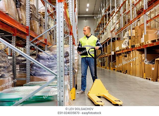 wholesale, logistic, loading, shipment and people concept - man with empty loader and clipboard at warehouse