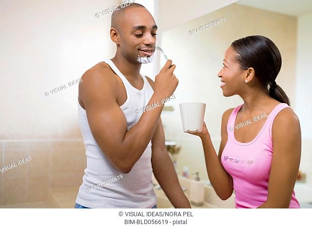 African woman watching husband shave