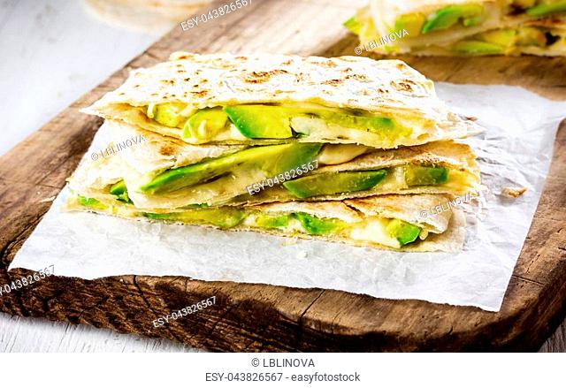 Mexican avocado quesadilla on gray plate, wooden background