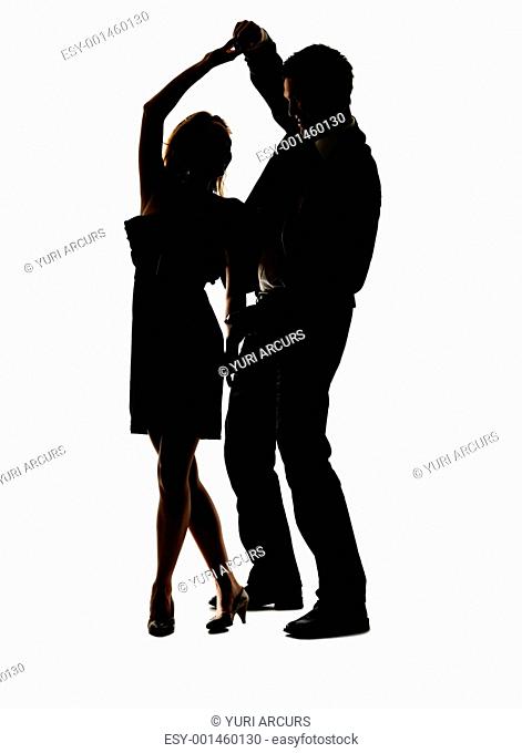 Portrait of a lovely young couple dancing together against white background