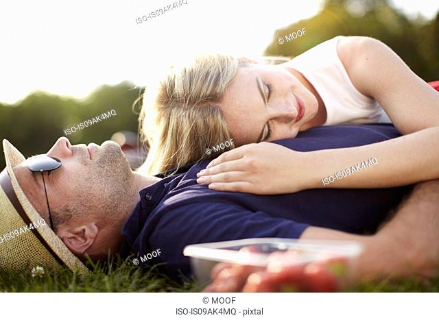 Couple lying asleep in park