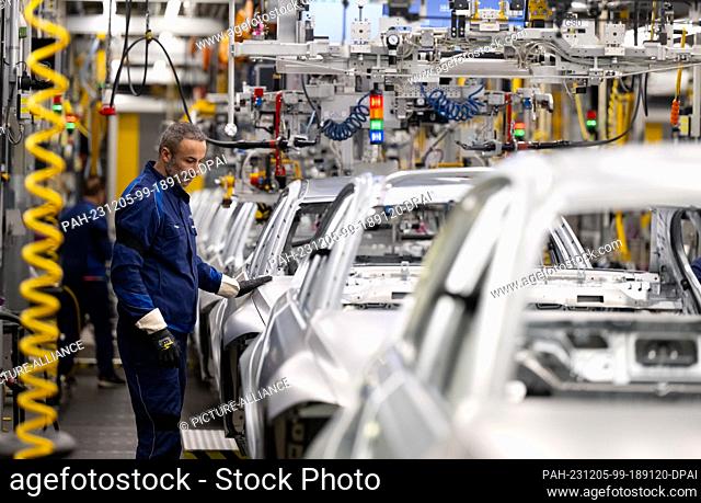 05 December 2023, Bavaria, Munich: BMW employees work in production during a tour of the plant by Chancellor Scholz (SPD). Photo: Sven Hoppe/dpa