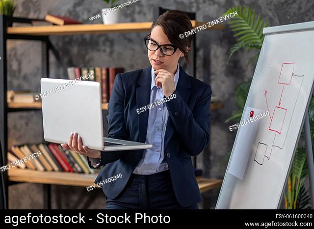 Business woman. Elegant dark-haired woman with a laptop in hands