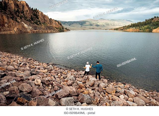 Couple walking on rocks beside Dillon Reservoir, elevated view, Silverthorne, Colorado, USA