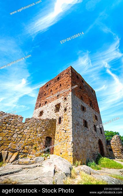 Old castle ruin in the summer under a blue sky with several windows and a brick wall