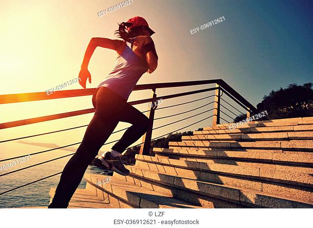 healthy lifestyle sports woman running up on stone stairs sunrise seaside