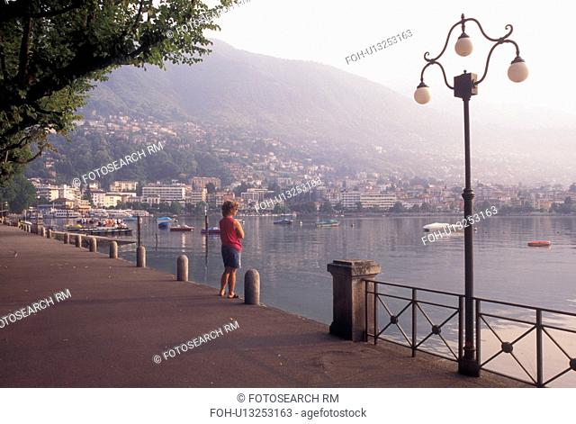 Switzerland, Ticino, Locarno, Woman standing on the lakefront of Lake Maggiore in the city of Locarno