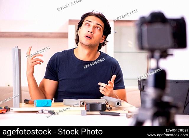 Young male repairman recording video for his blog