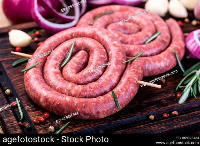 raw sausage on a wooden cutting board