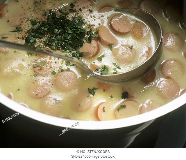 Seasoning potato soup with sausages