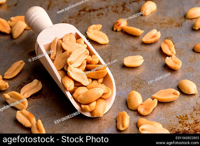 healthy natural brown peanuts on scoop on a steel plate