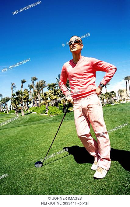 Man wearing pink clothes playing golf, USA