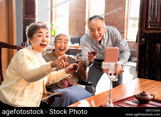 Happy old people use their phones to live a cup of tea