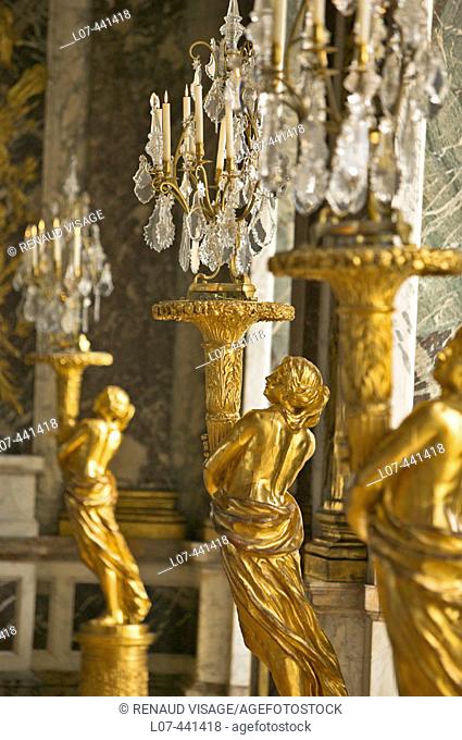 Golden statues holding lamps in the Hall of Mirrors. Chateau of Versailles. France