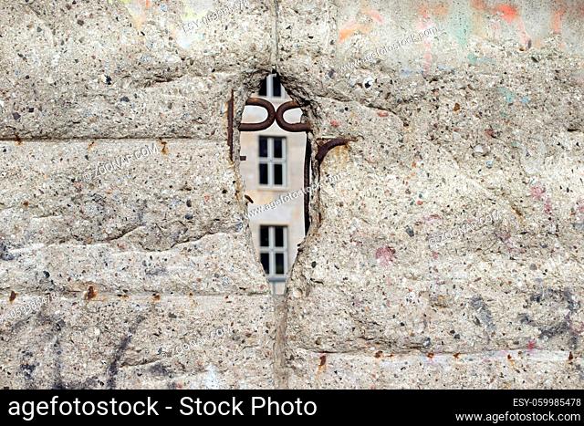 weathered fragment of Berlin wall with broken hole