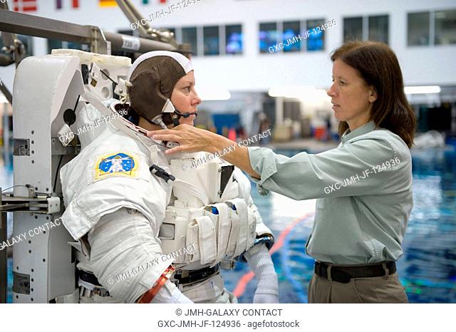 Astronaut Tracy Caldwell, Expedition 2324 flight engineer, dons a training version of her Extravehicular Mobility Unit (EMU) spacesuit in preparation for a...