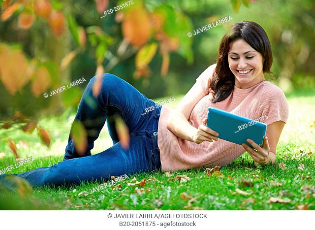 35 year old woman with digital tablet in park. Donostia. San Sebastian. Gipuzkoa. Basque Country, Spain