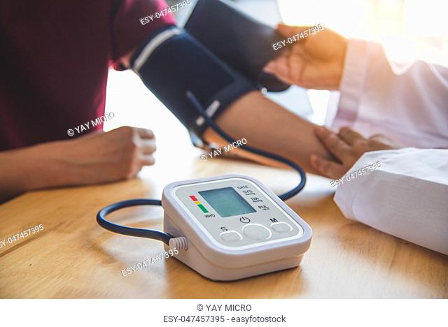 doctor measuring blood pressure from her patient