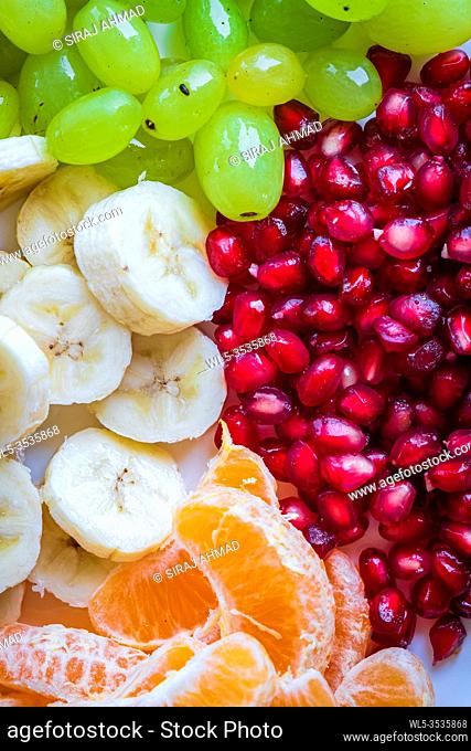 Healthy Breakfast Concept. Fresh fruits on the breakfast table. Close up of Grapes, banana, oranges, pomegranate. selective focus