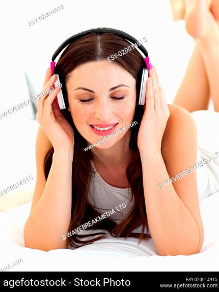 Quiet woman listening music lying on bed