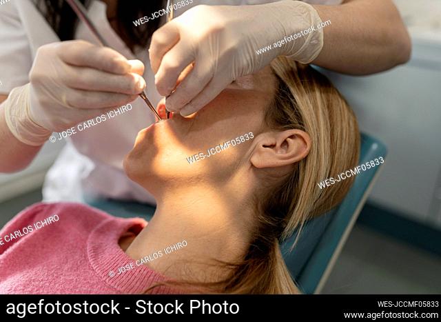 Dentist examining teeth of patient at dental clinic