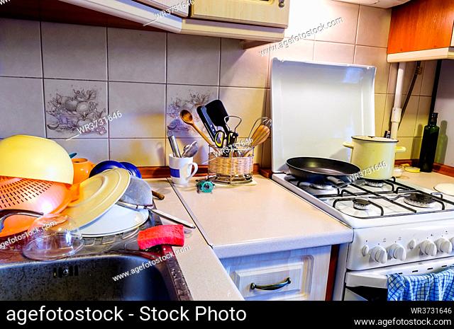 View of a kitchen with drying dishes, plates, cups and various kitchen tools