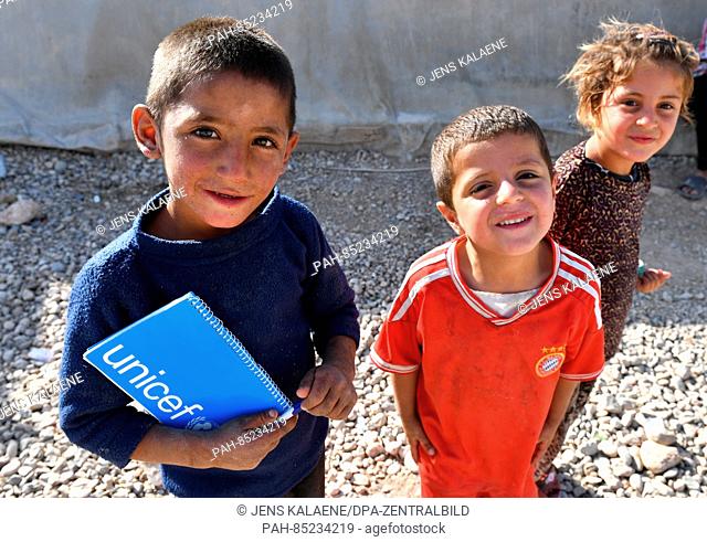 Refugee children stans with a UNICEF notepad in the Mamilian refugee camp in the Dohuk region, Iraq, 19 October 2016. Murat has received a small camera...