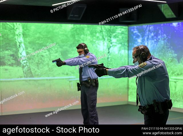10 November 2021, Saxony, Schneeberg: Two police officers train on the new space shooting range of the police technical school