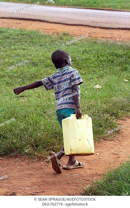 UGANDA  Boy carrying jerry can,  Village of Kabembe, Mukono District