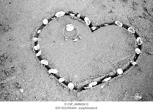 a heart on the sand in the beach black and white color tone style