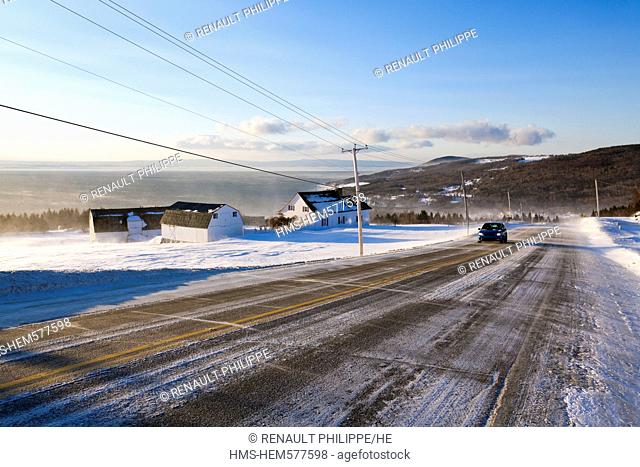 Canada, Quebec province, Charlevoix, St Irenee, the St Lawrence River Road snow covered field and traditional farm, road and winter driving