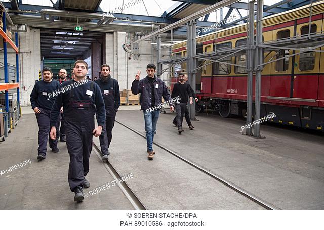 Members of a qualification class for young refugees walk through the train factory in Schoeneweide, Berlin, Germany, 14 March 2017