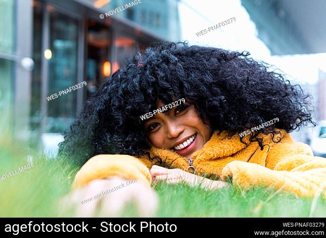 Smiling woman lying on grass