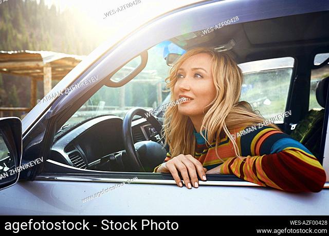 Thoughtful woman sitting in car on road trip