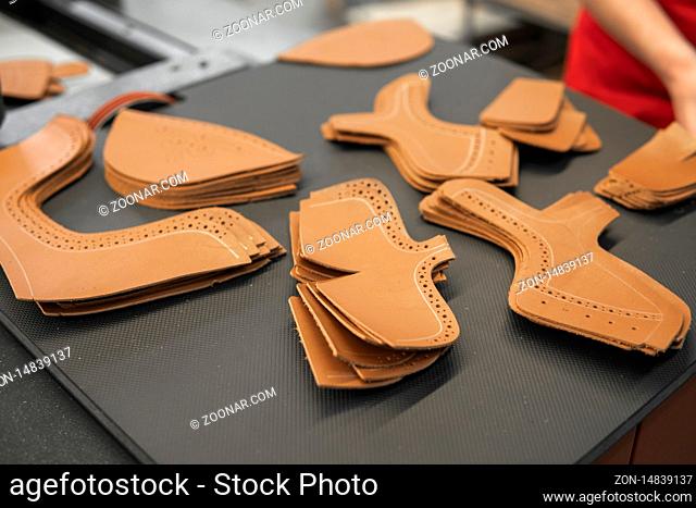 Different forms of leather pieces which will be use for making a shoes on a shoes factory. Prepared, bundled leather parts, used in the production of shoes