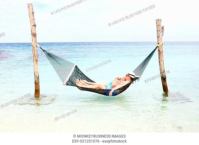 Senior Couple Relaxing In Beach Hammock