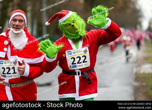 10 December 2023, Brandenburg, Michendorf: A participant runs through Michendorf in a Grinch Santa costume at the St. Nicholas Run