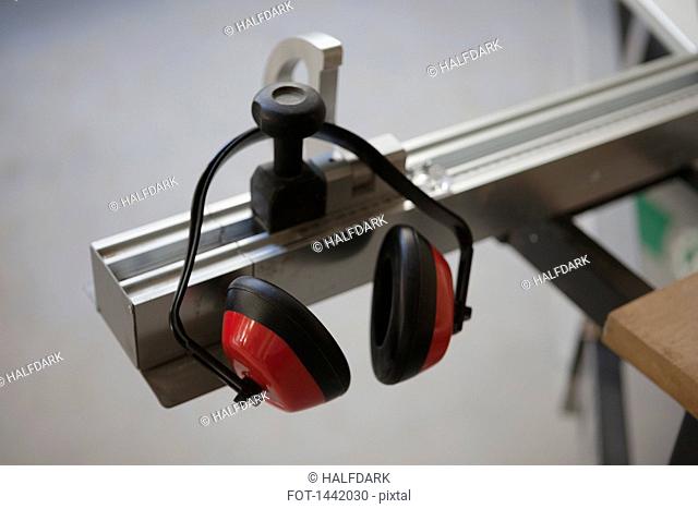 Ear protector hanging from sliding table saw in workshop