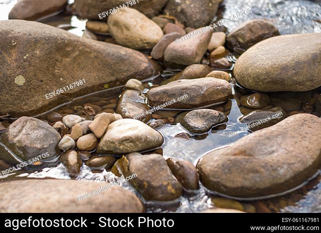 Brown stones in flowing river in Brazil