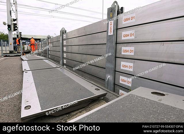 21 July 2021, Saxony, Dresden: Employees of the city of Dresden set up a mobile flood protection system on Schlachthofstraße for a test run