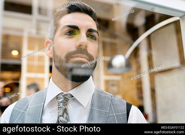 Handsome groom seen through glass material at home