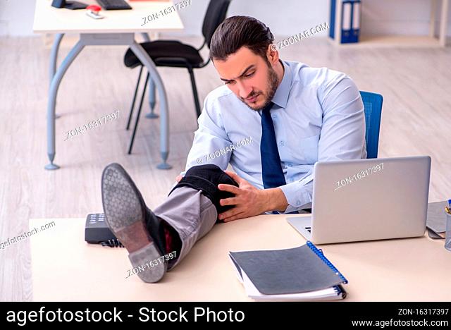 Young leg injured employee working in office