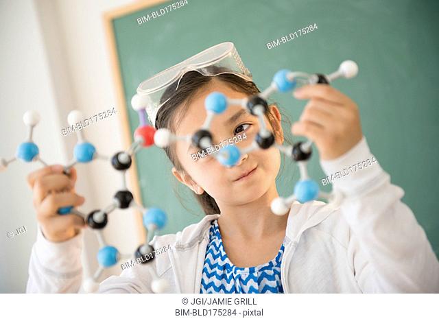 Girl examining molecular model in science class