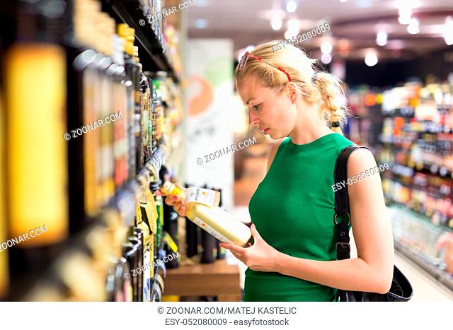 Beautiful caucasian woman shopping groceries at supermarket