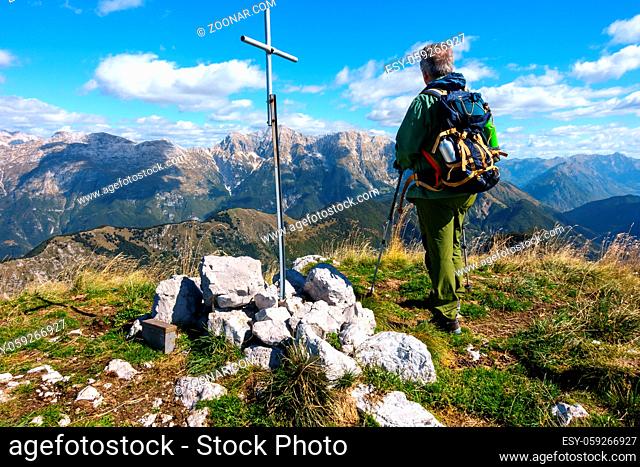 Man hiker, near the rood of top, on mountain top watching the mountain range